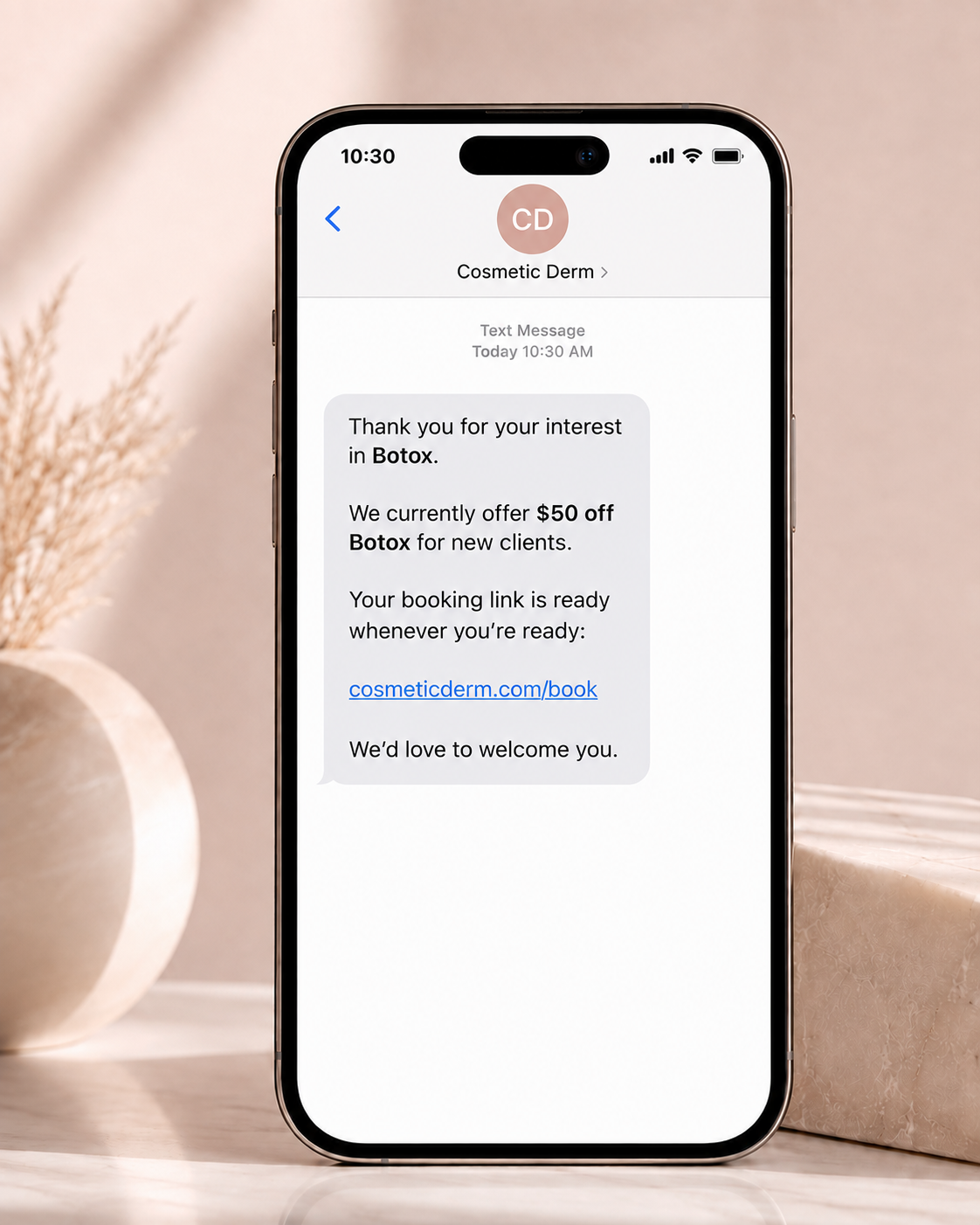 Phone showing an SMS from Cosmetic Derm about Botox, a $50 off offer for new clients and a booking link.